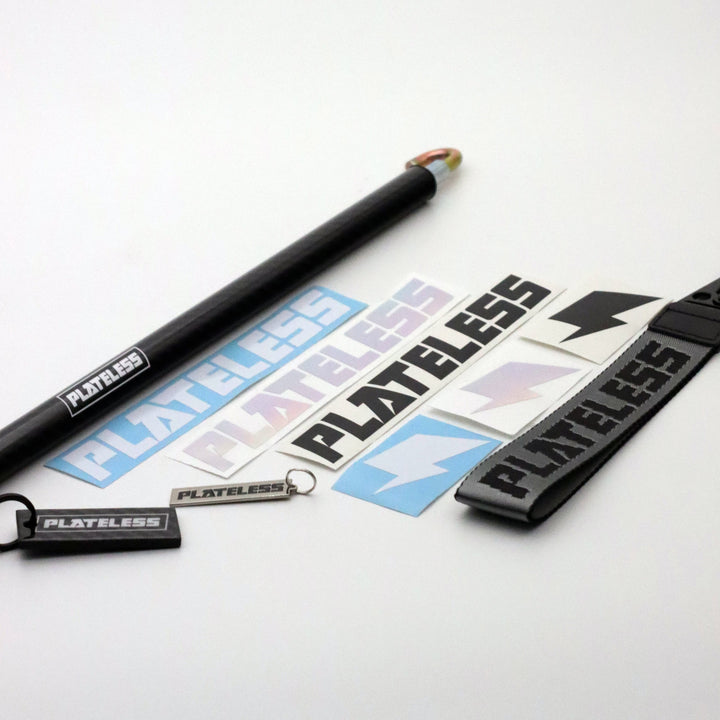 Collection of 'Plateless' branded items including a pen, keychain, and strap on a white background.